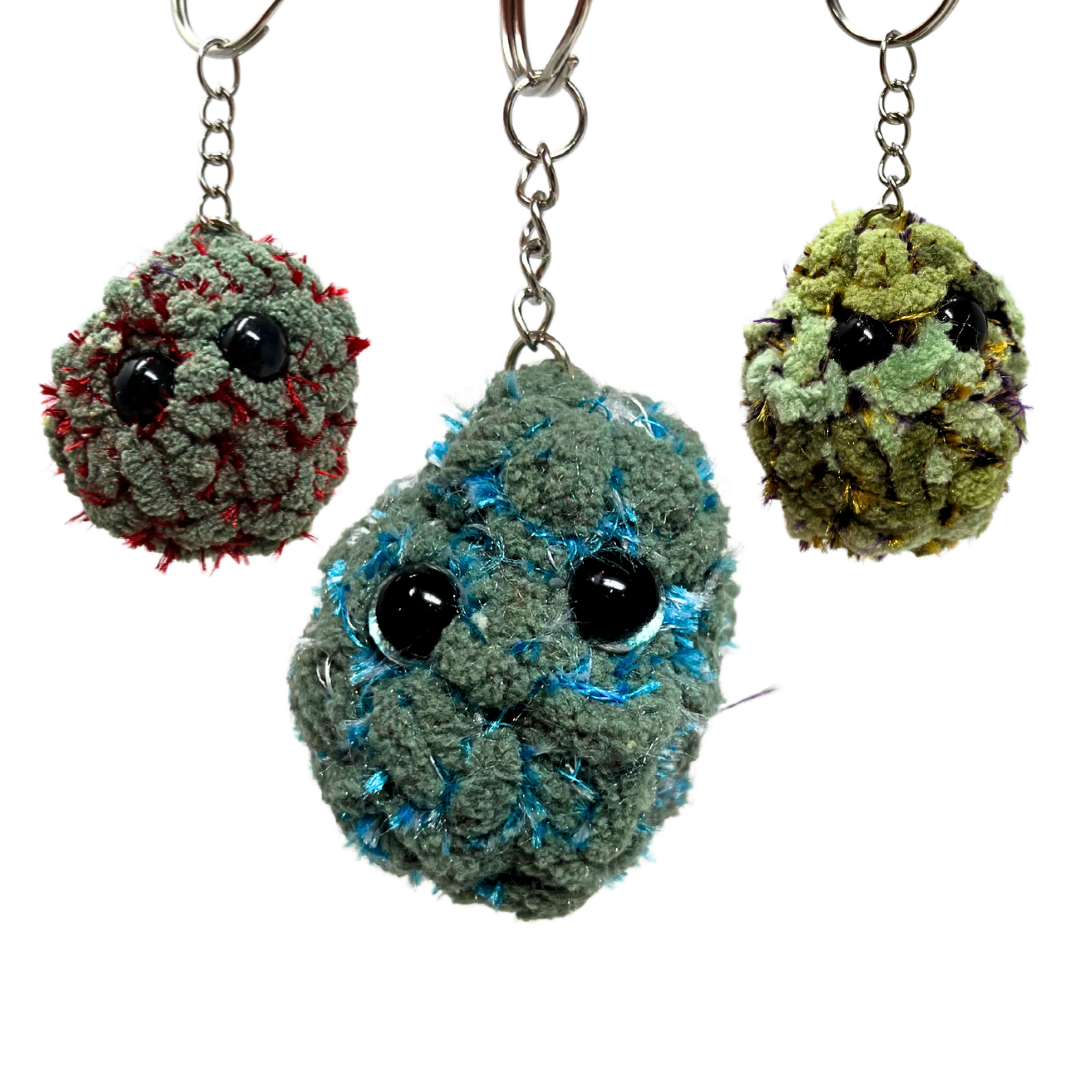 Group shot of Blue Dream, Red Velvet, and Super Boof nug keychains. Plush, handmade, and inspired by iconic cannabis strains.